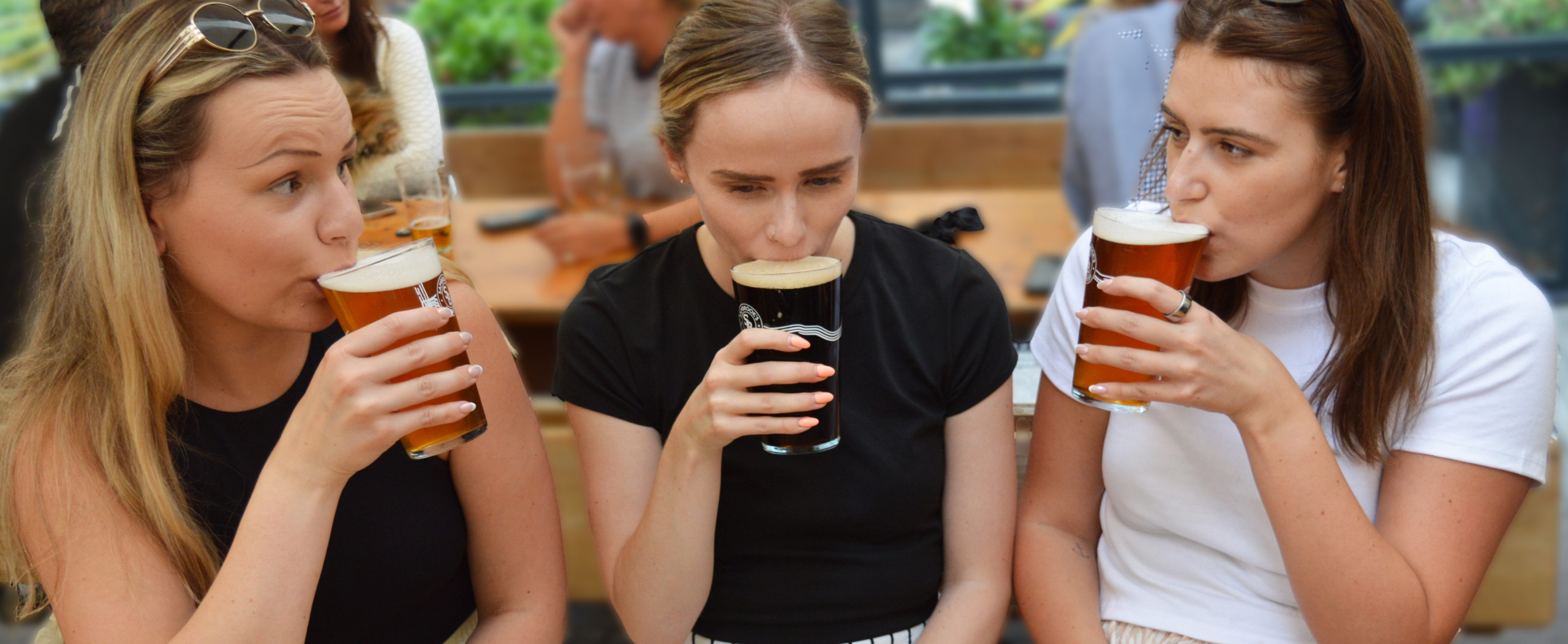 Three women drinking pints of beer